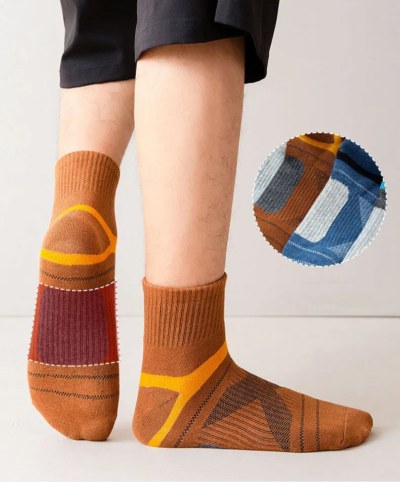 Brown socks with orange accents worn by a person on a plain background